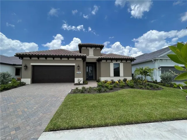 Mediterranean / spanish-style home featuring a garage, stucco siding, decorative driveway, and a front yard