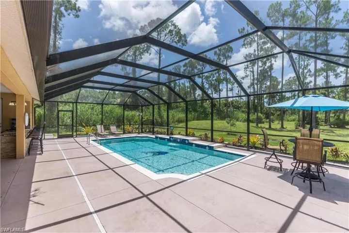 Swimming pool with a patio area, a lanai, a sunroom, and a lawn