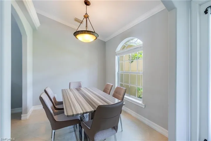 Dining room featuring arched walkways and ornamental molding