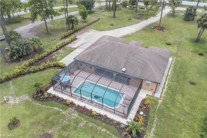 Aerial view of property and surrounding area featuring a pool area