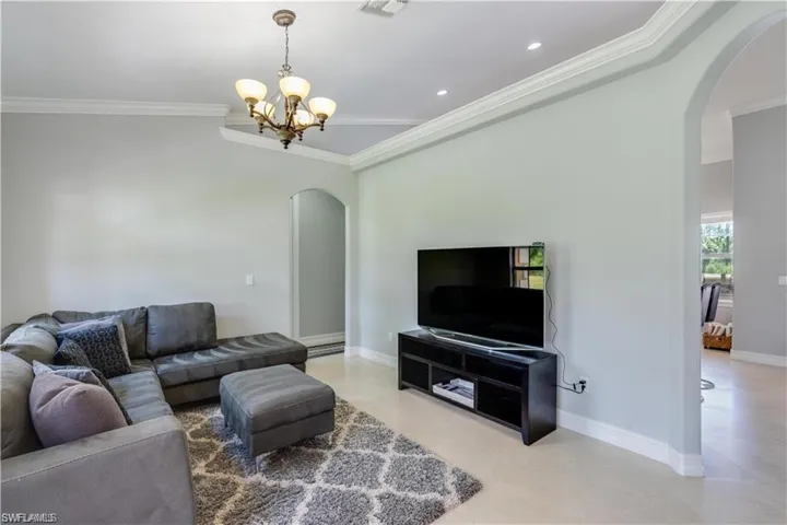Living area featuring arched walkways and crown molding