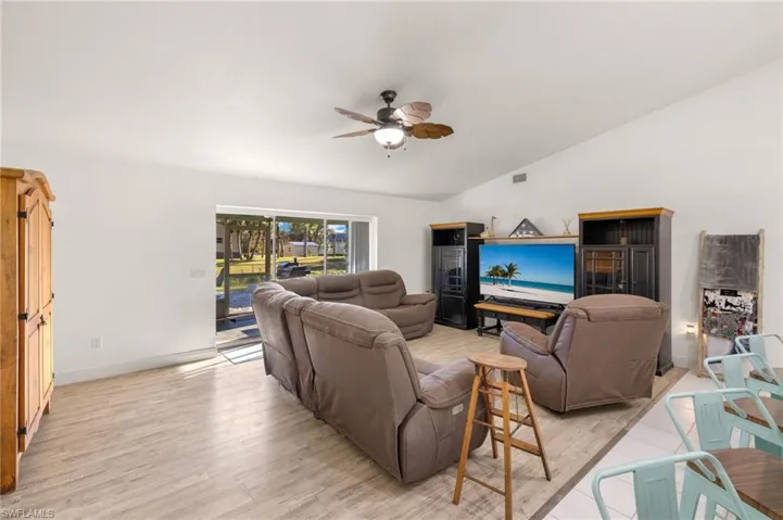 Living room featuring lofted ceiling, light hardwood / wood-style flooring, and ceiling fan