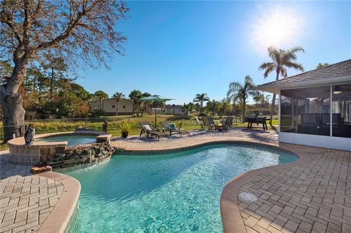 View of swimming pool with a patio, an in ground hot tub, and a sunroom