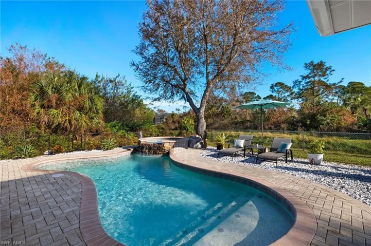 View of pool with an in ground hot tub and a patio area
