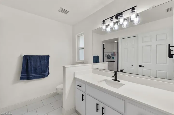 Bathroom featuring toilet, vanity, and tile patterned floors