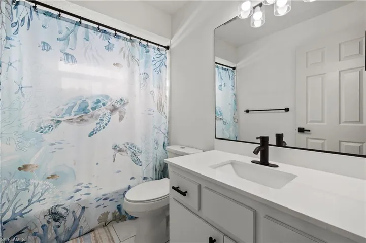 Bathroom featuring toilet, vanity, and tile patterned flooring