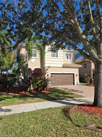 View of front of property with an attached garage, decorative driveway, stucco siding, and a front lawn