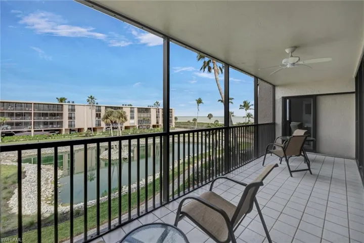 Unfurnished sunroom featuring a water view, floor to ceiling windows, a textured wall, and tile patterned floors