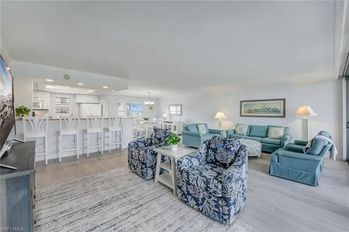 Living room with light wood-style floors, recessed lighting, a chandelier, and crown molding