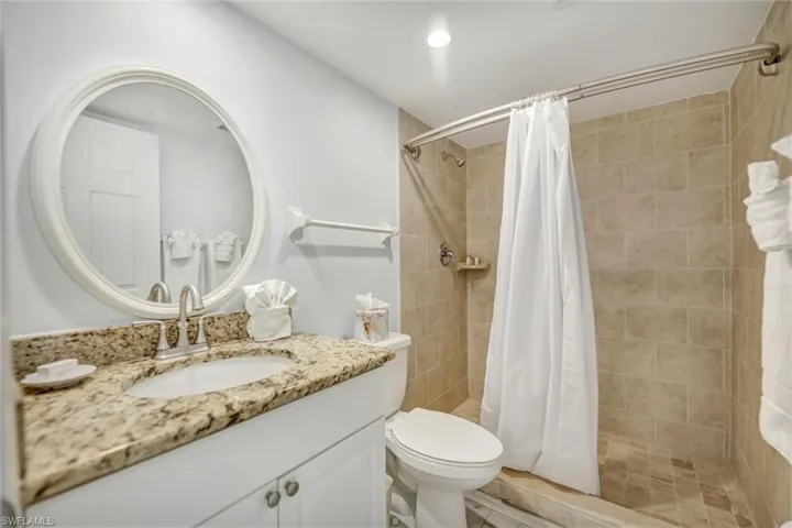 Full bathroom featuring vanity, a shower stall, and recessed lighting