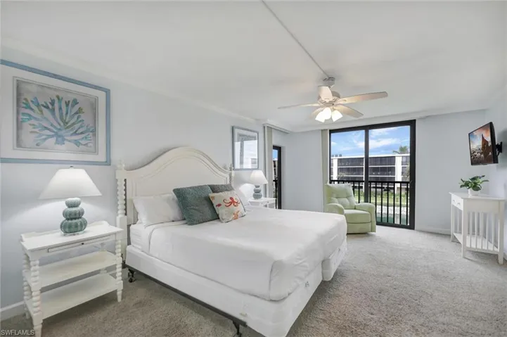 Carpeted bedroom featuring ornamental molding, access to exterior, ceiling fan, and floor to ceiling windows