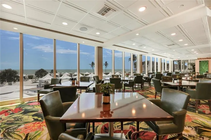 Dining area with a wall of windows, recessed lighting, and a water view