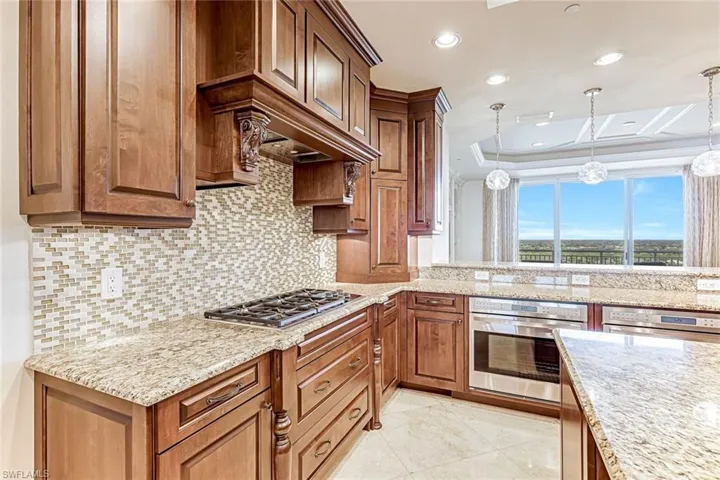 Solid wood cabinets, gas cooktop and mosaic backsplash.