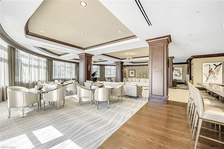 Elegant community lounge with detailed ceiling work, floor-to-ceiling windows, and sophisticated finishes.