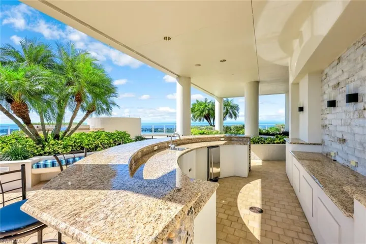 Rooftop terrace  bar area with granite counters, built-in cabinetry, and wide open water views.