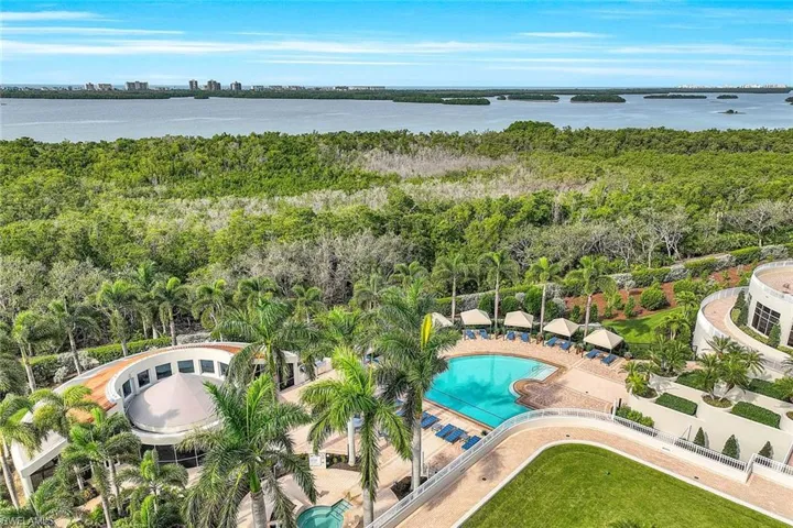Aerial view showcasing the resort-style pool, lush landscaping, and surrounding nature preserves.