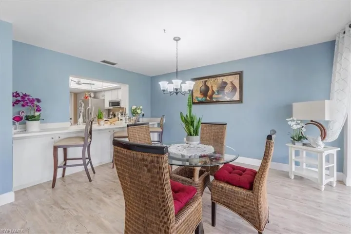 Dining room with light wood-style floors and a chandelier
