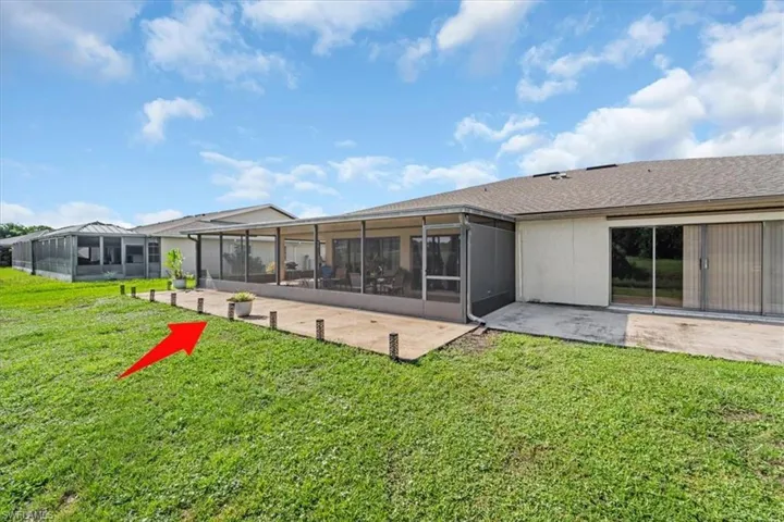 Back of property with a lawn, a patio, and a sunroom