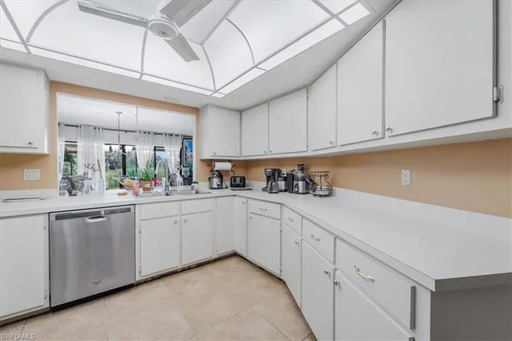 Kitchen with dishwasher, white cabinetry, light countertops, and ceiling fan