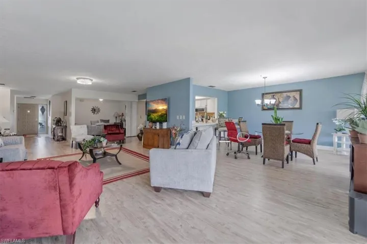 Living room with light wood finished floors and a chandelier