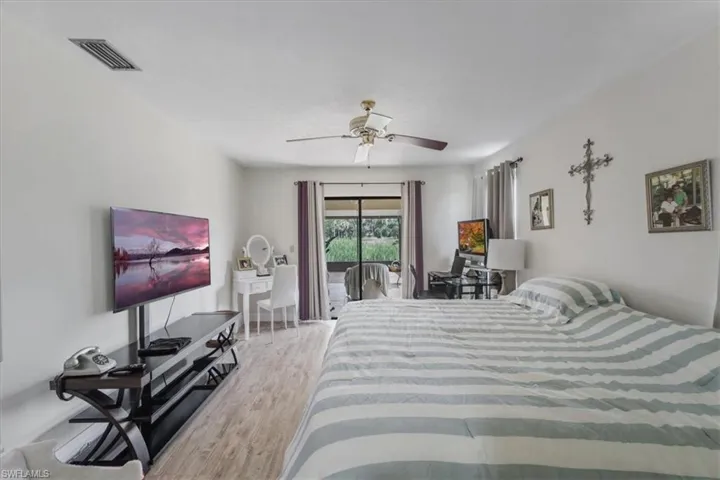 Bedroom with light wood-style floors, access to exterior, and ceiling fan