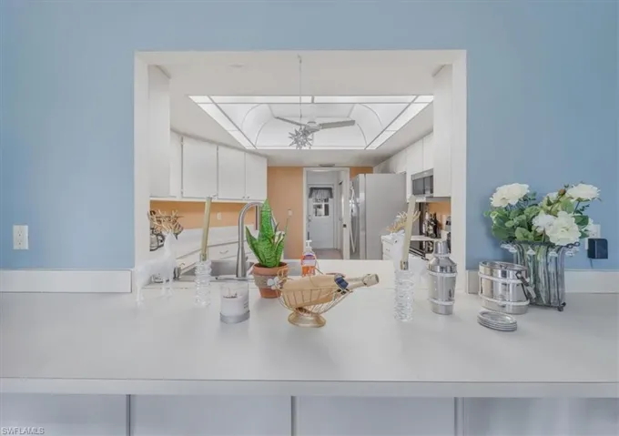 Kitchen featuring white cabinets, light countertops, electric stove, a peninsula, and stainless steel refrigerator with ice dispenser