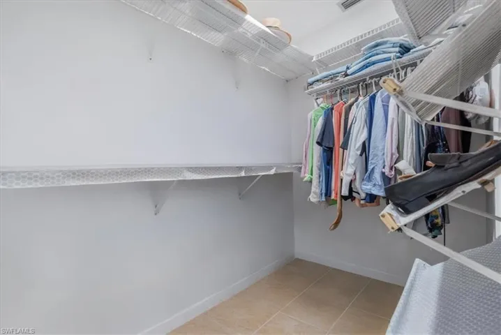 Walk in closet with light tile patterned floors