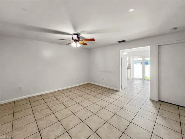 Ceramic tile flooring, ceiling fan with integrated lighting, and a sliding door leading to an exterior space