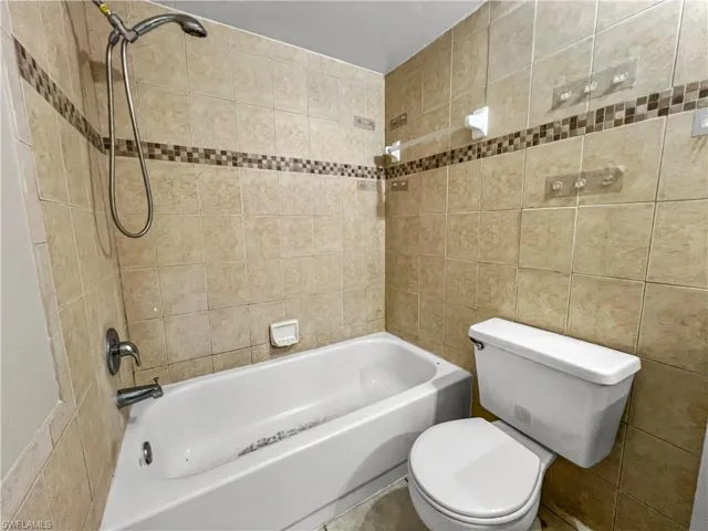 Tiled shower surround with decorative mosaic accent band