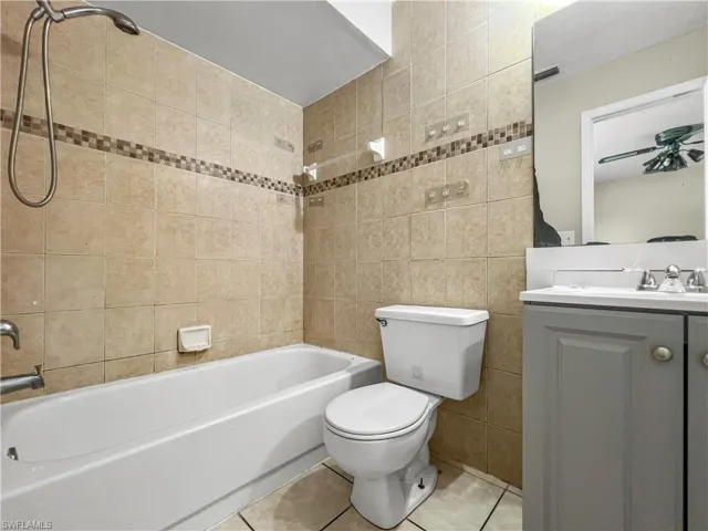 Tile flooring extending to the shower surround with a decorative accent band