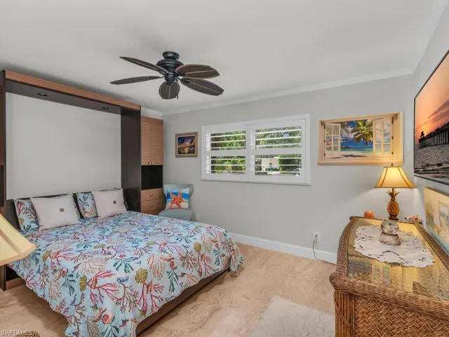 Bedroom with Murphy Bed ornamental molding and ceiling fan