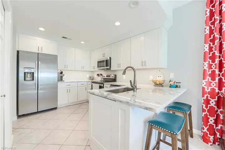 NEW SHAKER CABINETRY WITH QUARTZ COUNTERTOPS, NEW LIGHTING AND NEW PLUMBING FIXTURES, AND STAINLESS STEEL APPLIANCES
