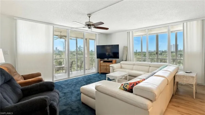 Living room with floor to ceiling windows and a textured ceiling - Virtually Edited Image