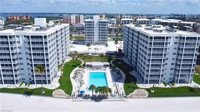 View of community pool area featuring a pool & condominium buildings, 7146 Estero Blvd-left, 7150 Estero Blvd-right, center building straight back 7148 Estero Blvd- Virtually Edited Image
