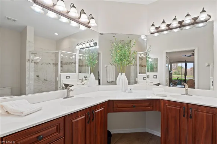 Bathroom featuring toilet, tile patterned floors, a shower with door, and vanity