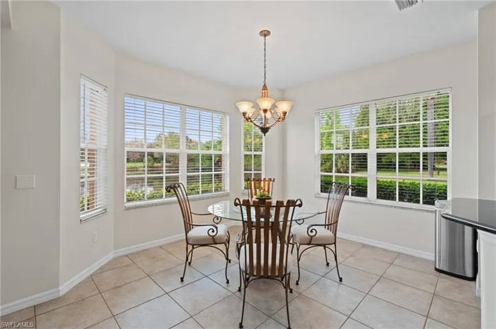 Tiled dining space featuring an inviting chandelier and a wealth of natural light