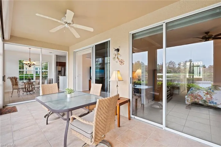 Sunroom with ceiling fan with notable chandelier