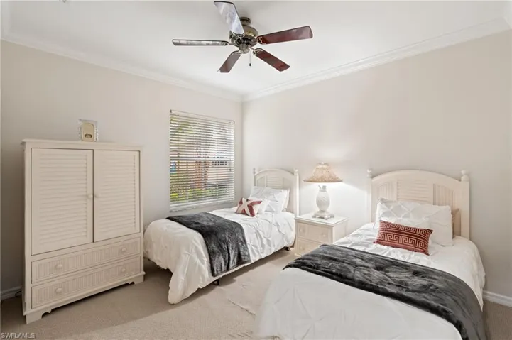 Carpeted bedroom featuring ceiling fan and ornamental molding