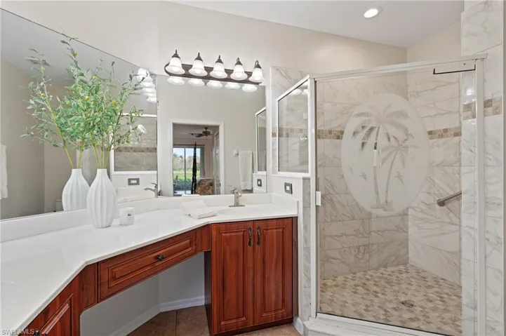 Bathroom with vanity, tile patterned floors, and a shower with door
