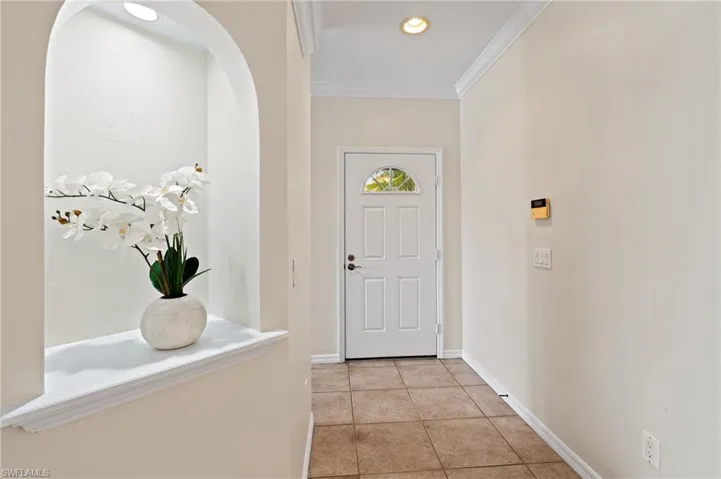 Tiled foyer entrance featuring ornamental molding
