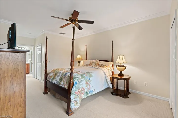 Bedroom featuring ceiling fan, carpet floors, and crown molding