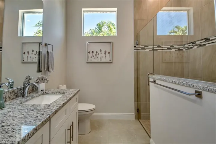 Full bathroom with vanity, a walk in shower, and light tile patterned flooring