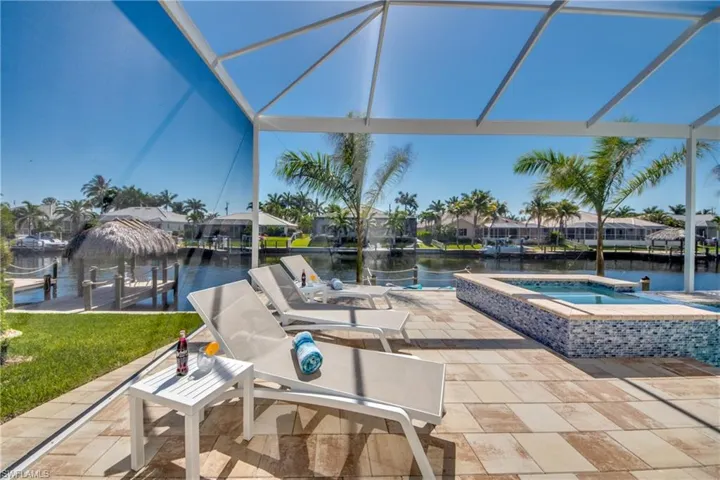 View of patio / terrace featuring a water view, glass enclosure, and a sunroom
