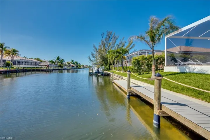 Dock area with a water view and a yard