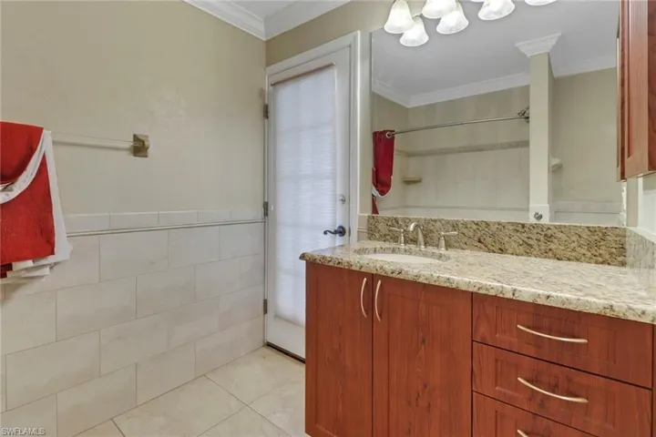 Bathroom featuring vanity, crown molding, and tile patterned floors