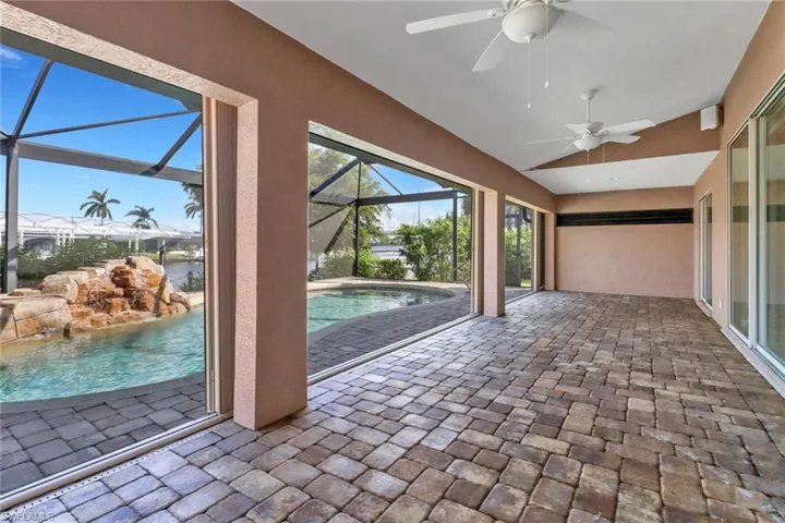 Unfurnished sunroom with lofted ceiling, a swimming pool, and ceiling fan