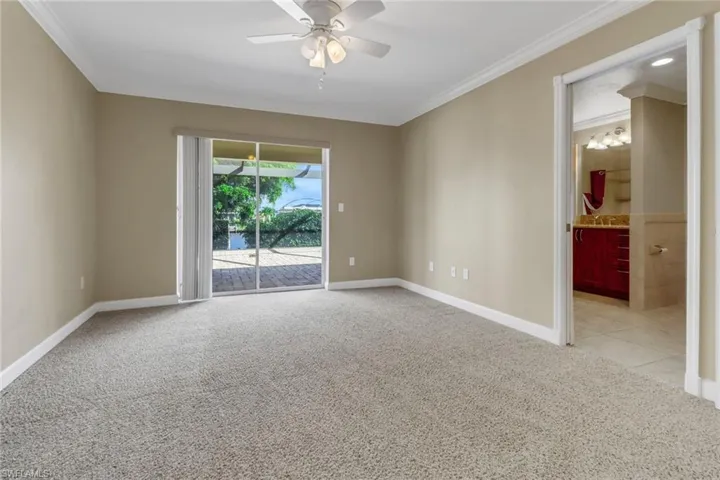 Unfurnished room with ornamental molding, ceiling fan, and light colored carpet
