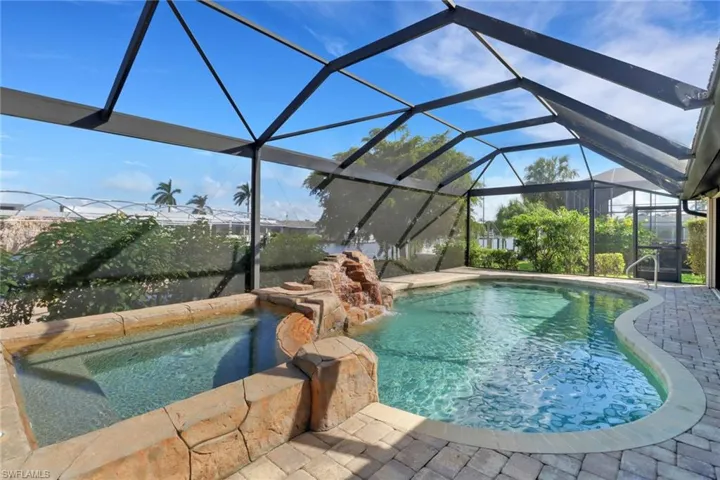 View of swimming pool featuring glass enclosure and a patio