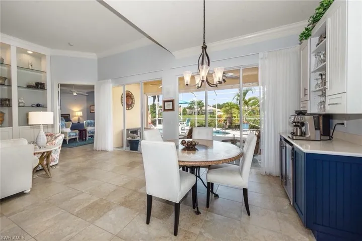 Matching kitchen built in server with wood , cabinets and wine chiller .quartz counter top Great room concept with Double crown moldings, baseboard, tile flooringover looking lake views