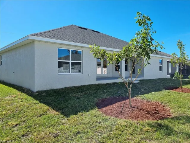 Rear view of house featuring a patio area and a yard
